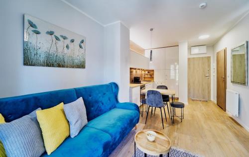 sala de estar con sofá azul y mesa en LAGUNA Apartament Polanica Residence 38, en Polanica-Zdrój