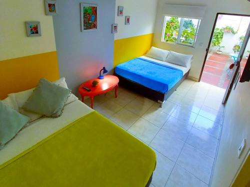 a small room with two beds and a table at Casa Azul Boutique Hostel in Pereira