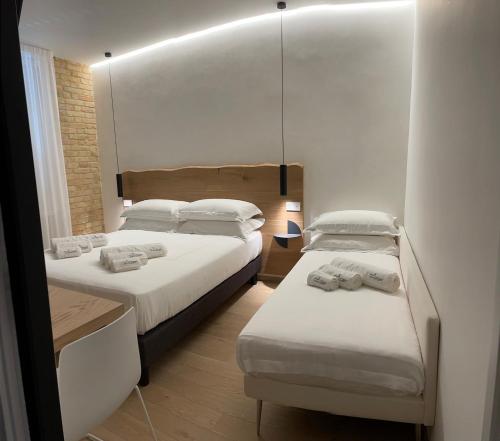 una camera con due letti e uno specchio di Civitaloft Luxury Rooms a Civitanova Marche