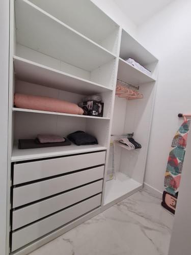 a white closet with white shelves in a room at Premium class Apartmant - free parking in Zadar
