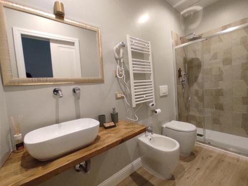a bathroom with a sink and a shower and a toilet at Manno Rooms Affittacamere in Cagliari