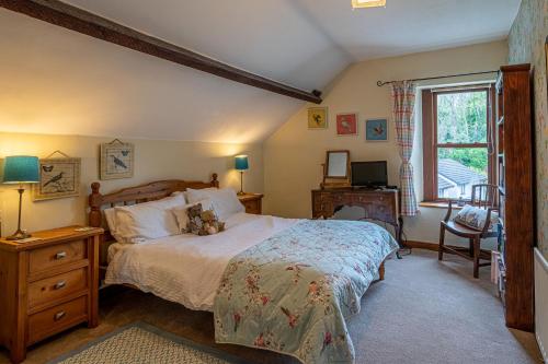 a bedroom with a large bed and a window at The Old Post Office in Grange Over Sands