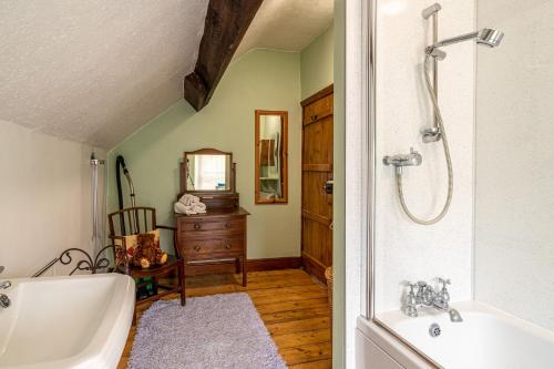 a bathroom with a bath tub and a sink at The Old Post Office in Grange Over Sands