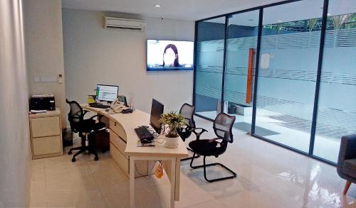an office with a desk with chairs and a computer at LeGreen Suite Sudirman in Jakarta