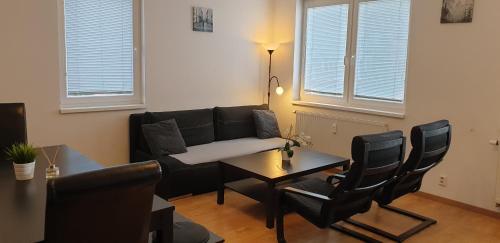 a living room with a couch and a table and chairs at APARTMÁN***BRATISLAVA in Bratislava