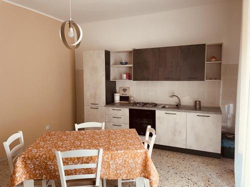 uma cozinha com uma mesa e cadeiras numa cozinha em Nausicaa Beach and Town em Agropoli