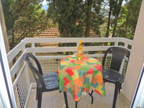 a table and chairs on a balcony with a bottle of wine at Villa Seka in Budva