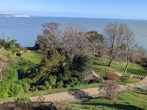 a garden with a bench and the ocean in the background at Sea View in Shanklin