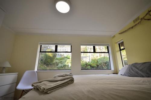 a bedroom with a bed and two windows at Bonito in Ventnor