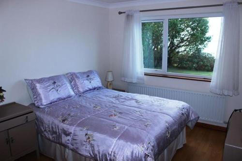 Un dormitorio con una cama grande y una ventana en Waterside Cottage, Cashel en Galway