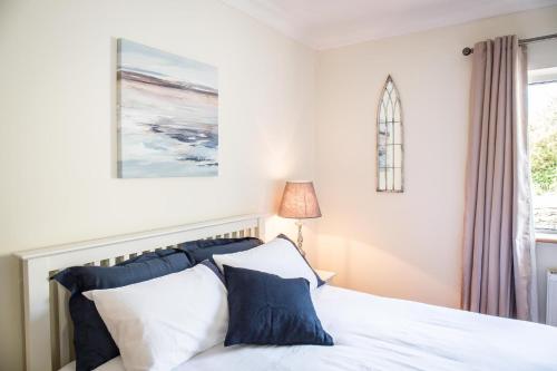 a bedroom with a bed with blue and white pillows at Once Upon a Tide in Clifden