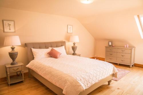 a bedroom with a bed with two night stands and two lamps at Once Upon a Tide in Clifden
