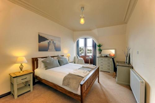 a bedroom with a bed and a dresser and a window at Argyll Mansions in Oban