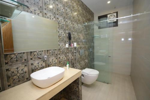 巴雷利的住宿－JM Vistaraa，浴室配有卫生间、盥洗盆和淋浴。
