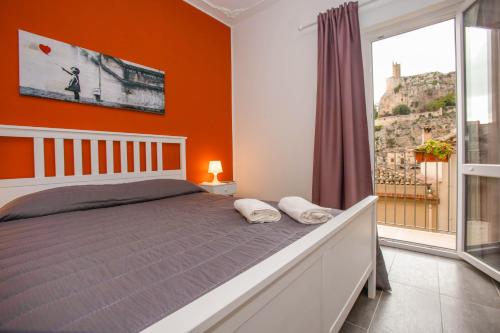 a bedroom with orange walls and a bed with two pillows at La Finestra Sul Castello - Modica Panoramic Flats in Modica