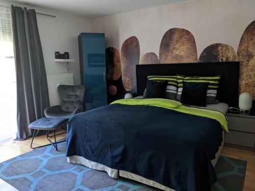 a bedroom with a large bed and a chair at Apartment Blue Regensburg in Regensburg