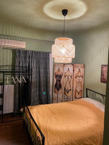1 dormitorio con cama y lámpara de araña en Cosy and comfort flat, heart of Athens en Athens