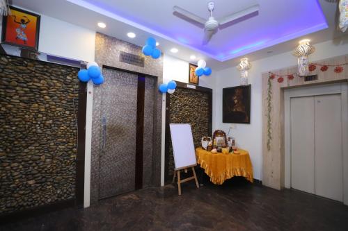 a room with a table and a door with blue balloons at JM Vistaraa in Bareilly