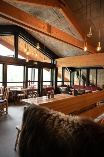a large room with tables and chairs and windows at Trolltun Hotel & Hytter in Dombås
