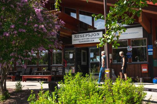 two people walking in front of a restaurant at Trolltun Hotel & Hytter in Dombås