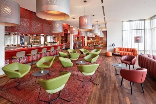 um restaurante com cadeiras verdes e um bar em Asia Hotel & Spa Leoben em Leoben