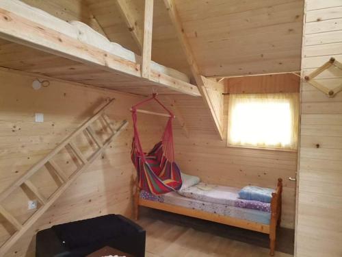 a room with a hammock in a log cabin at kamp Bungalovi sase apartman in Višegrad