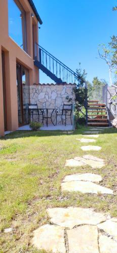 a stone walkway with two benches in front of a building at Stone hause Noa in Rab