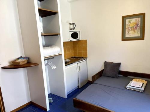 Cette petite chambre comprend un lit et une petite cuisine. dans l'établissement Studio CV - Calme, clair avec terrasse, à Montpellier