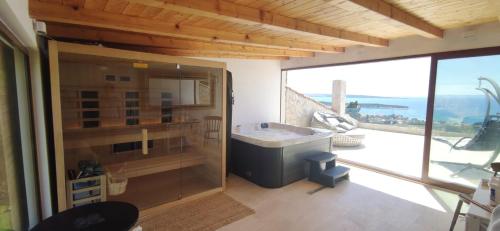 a large bathroom with a tub and a large window at Stone hause Noa in Rab