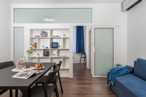 ein Wohnzimmer mit einem Tisch und einem blauen Sofa in der Unterkunft Apartmani Artqart Rijeka in Rijeka