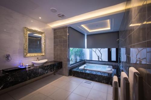 a bathroom with a tub and a sink at U-Her Hotel in Taichung