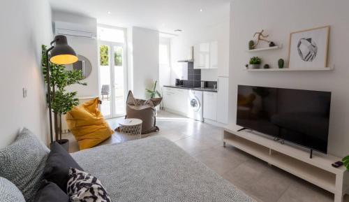 un salon avec une grande télévision à écran plat dans l'établissement MaxBnb - CLIMATISÉ - T2 37m2 & terrasse 30m2 - Est, à Toulon