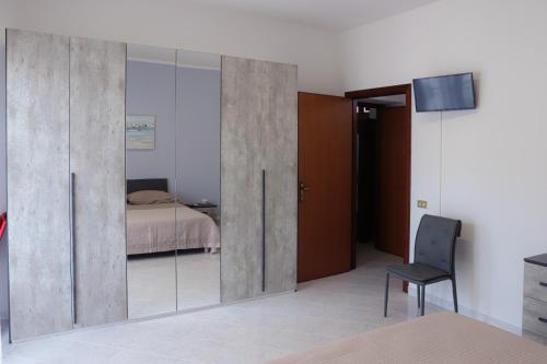 sypialnia z przesuwnymi szklanymi drzwiami i łóżkiem w obiekcie B&B LA CASA DEI FIORI w mieście Amorosi