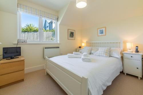 a bedroom with a large bed and a television at 4 Pentire Rocks in Polzeath