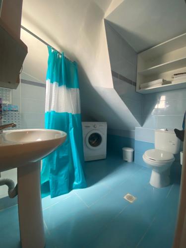 La salle de bains bleue est pourvue d'un lavabo et de toilettes. dans l'établissement Galini Apartment, à Karpathos