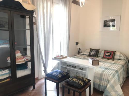 a bedroom with a bed with a desk and two stools at CARPE DIEM Stagnone in Marsala