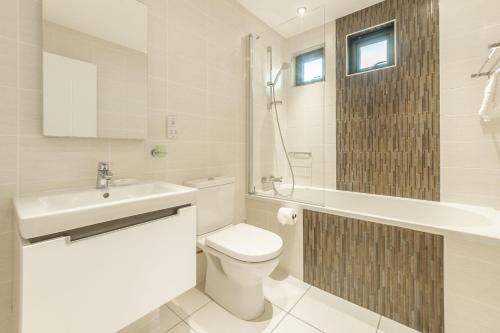 a white bathroom with a toilet and a sink at Sea Gem in St. Agnes 