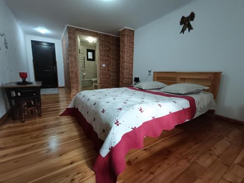 a bedroom with a large bed and a brick wall at CASA DINTRE PINI in Păltinoasa