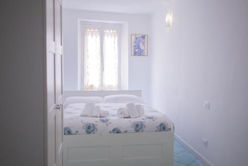 a bed in a white room with a window at Viadeibanchi in Riomaggiore