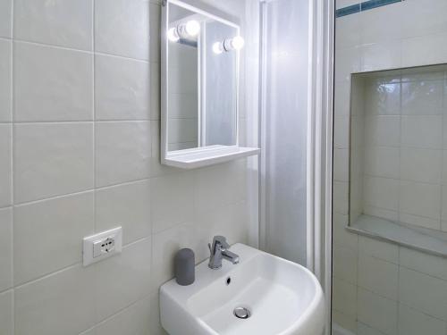 a white bathroom with a sink and a mirror at Viadeibanchi in Riomaggiore