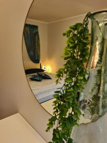 a mirror reflecting a bedroom with a bed in a room at Eneide in Palmi