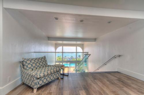a living room with a chair and a window at Oceanside Marina Suites - A Waterfront Hotel in Oceanside