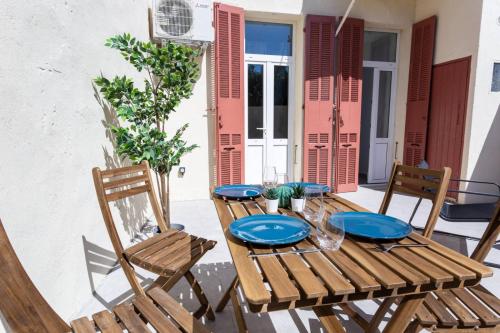 uma mesa de madeira e cadeiras num pátio em MaxBnb - CLIMATISÉ - Grand Studio 37m2 & terrasse 30m2 - Est em Toulon