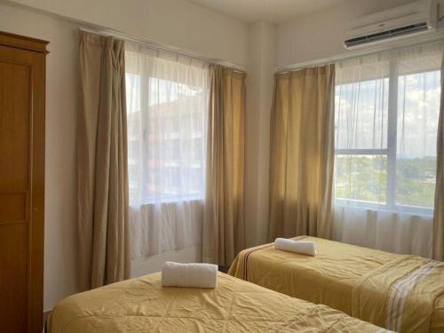 sypialnia z 2 łóżkami i oknem w obiekcie D’lina pelangi w mieście Kampong Kemaman