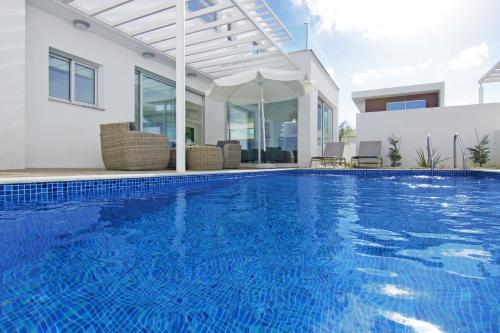 - une piscine en face d'une maison dans l'établissement Villa Violanta, à Ayia Napa