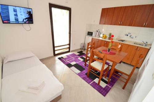 a kitchen and dining room with a table and chairs at Apartments Blue Lagoon in Kotor