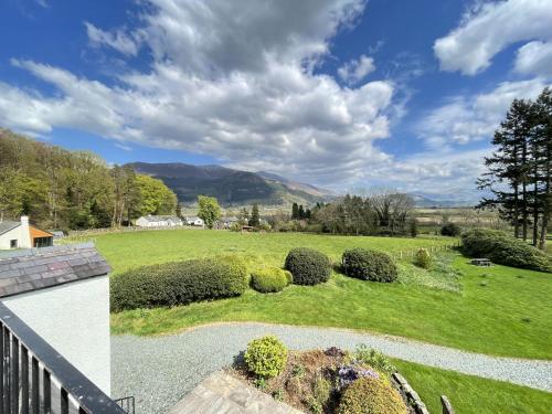 a view of a yard with bushes and a field at Lake View Cottage in Braithwaite