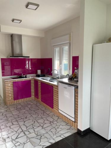 - une cuisine avec des placards violets et un réfrigérateur blanc dans l'établissement La casa de Anne, à Ribadumia