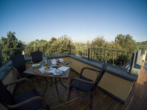 a wooden deck with a table and chairs on a balcony at Poggio Degli Olivi in Monsummano