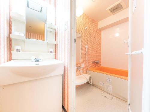 uma casa de banho com um lavatório, um WC e uma banheira em Tabist Hotel Aurora Ikebukuro em Tóquio